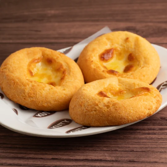 Arepas tres quesos horneadas servidas sobre un plato